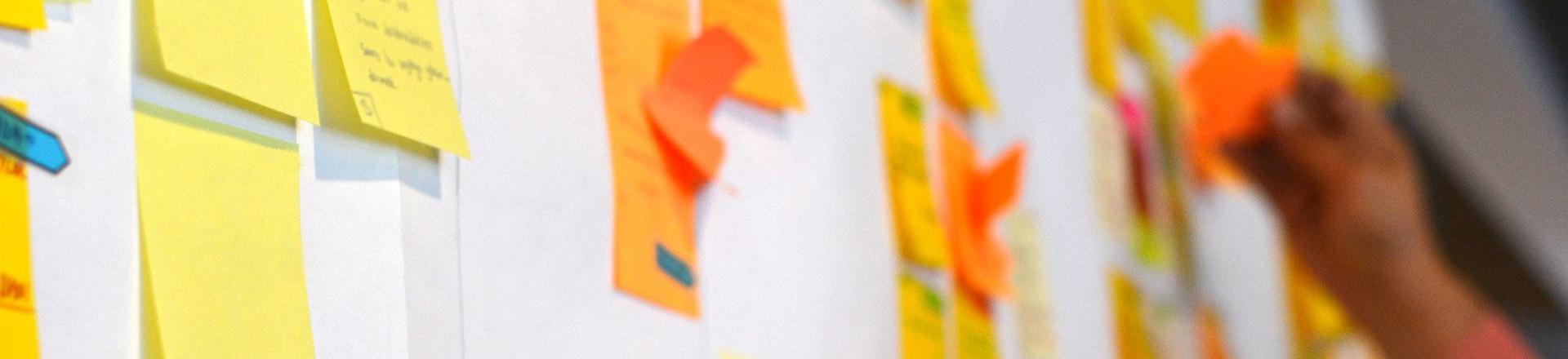 Close-up of colourful sticky notes on a planning wall, representing the early ideas and structure behind a company retreat agenda.
